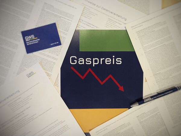 Flyer mit Überschrift Gaspreis und abwärts zeigendem Pfeil, drumherum weitere Papiere