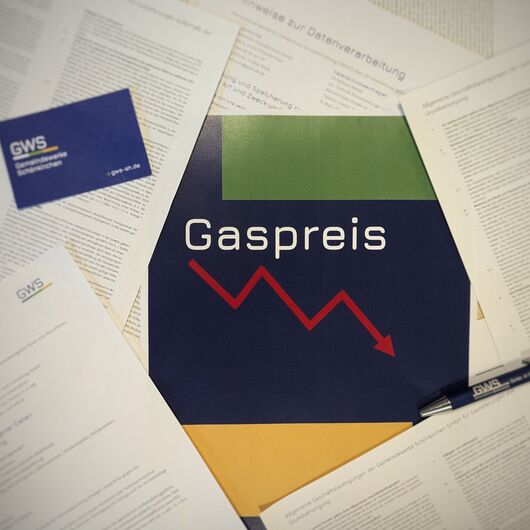 Flyer mit Überschrift Gaspreis und abwärts zeigendem Pfeil, drumherum weitere Papiere