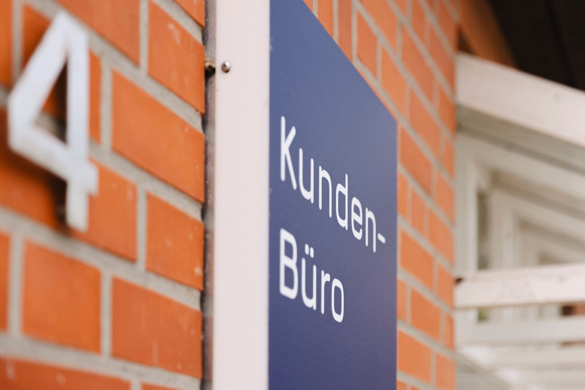 Schild mit Aufschrift Kunden-Büro an einer Hauswand